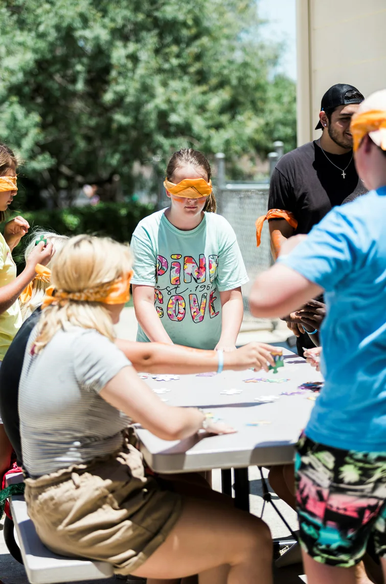 Jeunes du cégep lors d'une activité de groupe les yeux bandés, autour d'une table