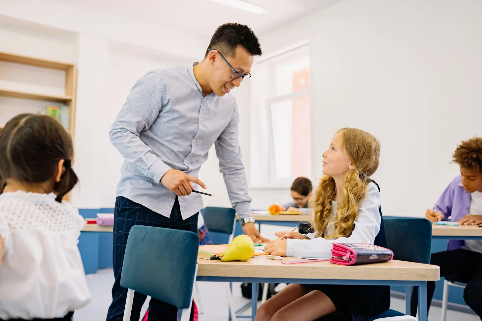 Enseignant qui échange avec des élèves dans une salle de classe